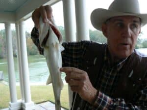 Ray Scott shows how to tell a male from a female bass. Just kidding.