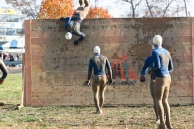 Tough Mudder participants scaling a wall, among other brutal obstacles.