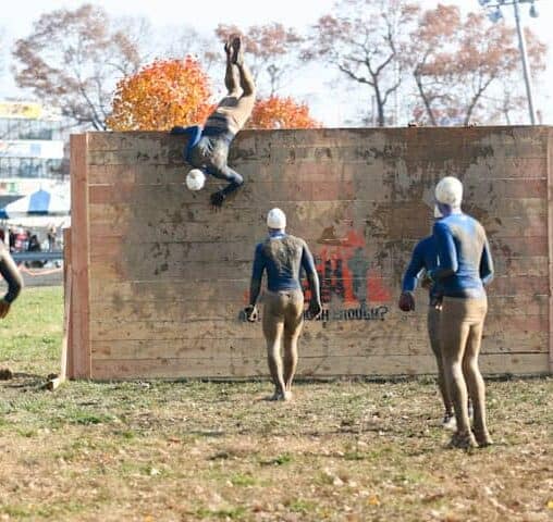 Tough Mudder participants scaling a wall, among other brutal obstacles.
