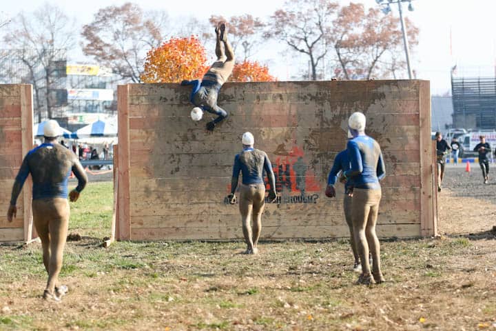 Tough Mudder participants scaling a wall, among other brutal obstacles.
