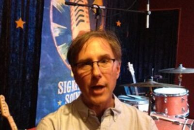 Jim Olsen at his new downtown office in front of the stage.