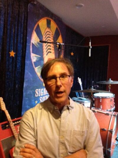 Jim Olsen at his new downtown office in front of the stage.