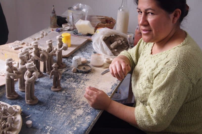 Rosita Loja, miniature maker, hand paints tiny figures with great detail in a country home workshop outside Cuenca.