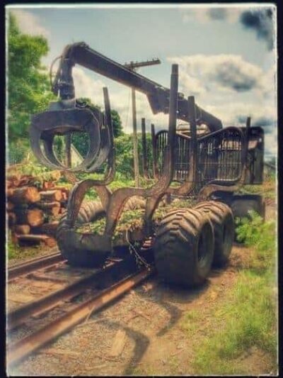 A logging machine takes a turn and then heads right down the railroad tracks today in South Deerfield, MA.