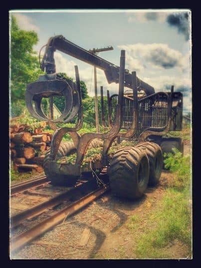 A logging machine takes a turn and then heads right down the railroad tracks today in South Deerfield, MA.