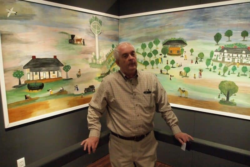 Thomas Whitehead, an art historian, with Clementine Hunter's murals which were recently installed in the Northwest Louisiana History museum.