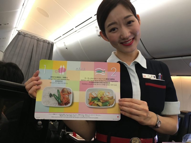  A flight attendants hows me the menu for Premium Economy on Japan Airlines.