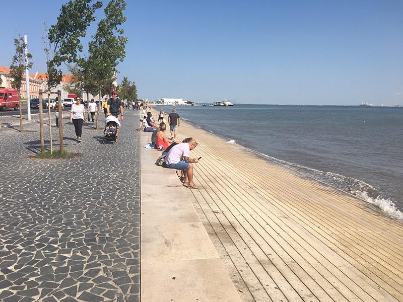 Along the Targus River, tourists and locals enjoy a sunny day in Lisbon. 