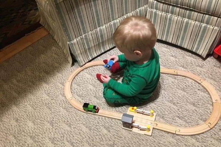 Freddy plays with a train set at Christmas.