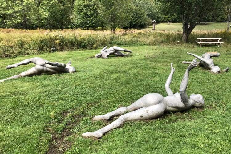 Aluminum bathers lie in repose and some dot the banks of a man-made pond at the Griffis Sculpture Park.